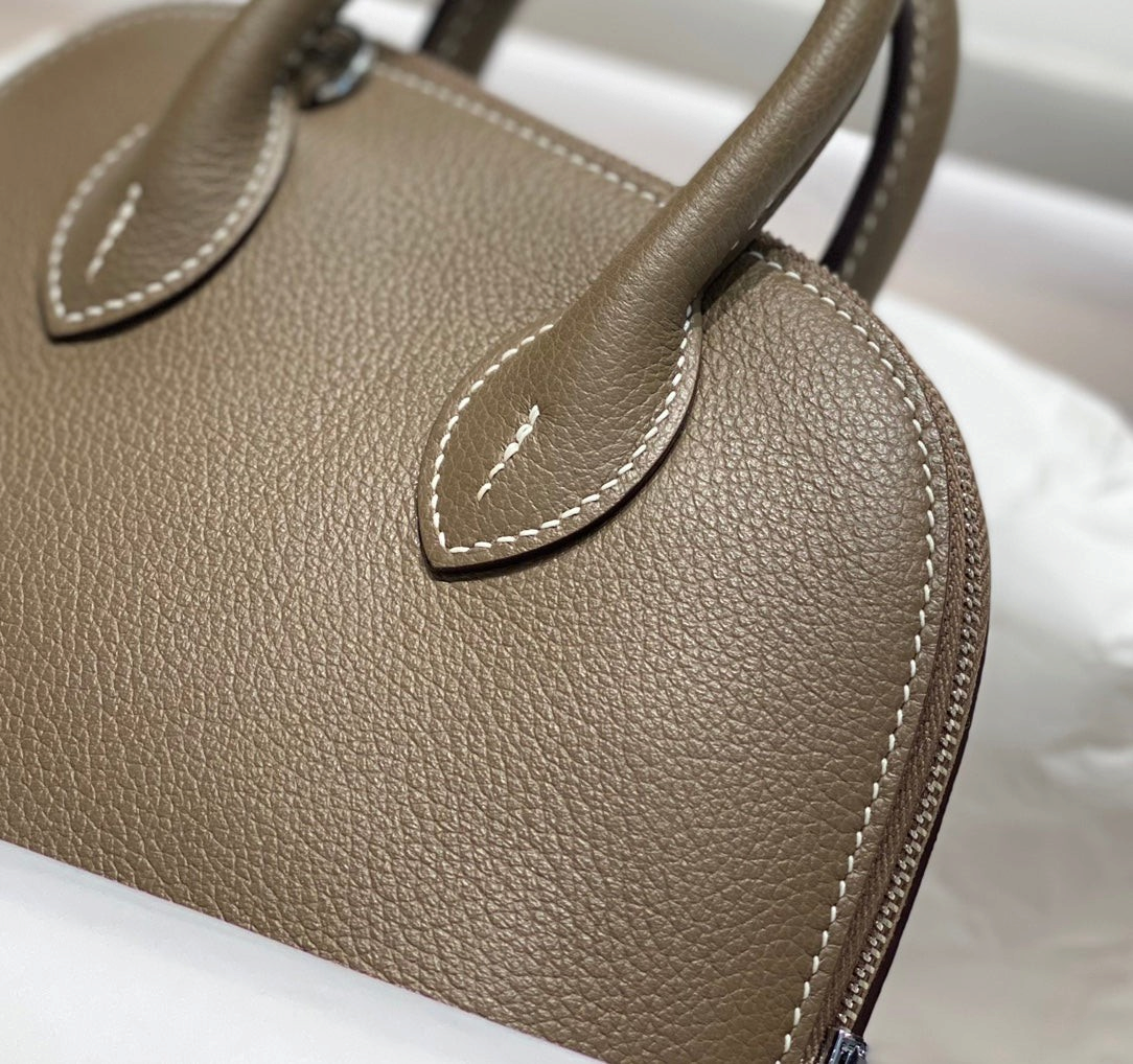 SWORD LUXURY Hermès Bolide Mini 19 çanta, taupe renkli damarlı deri, ikonik kubbe silüeti ve zarif dikiş detayları.