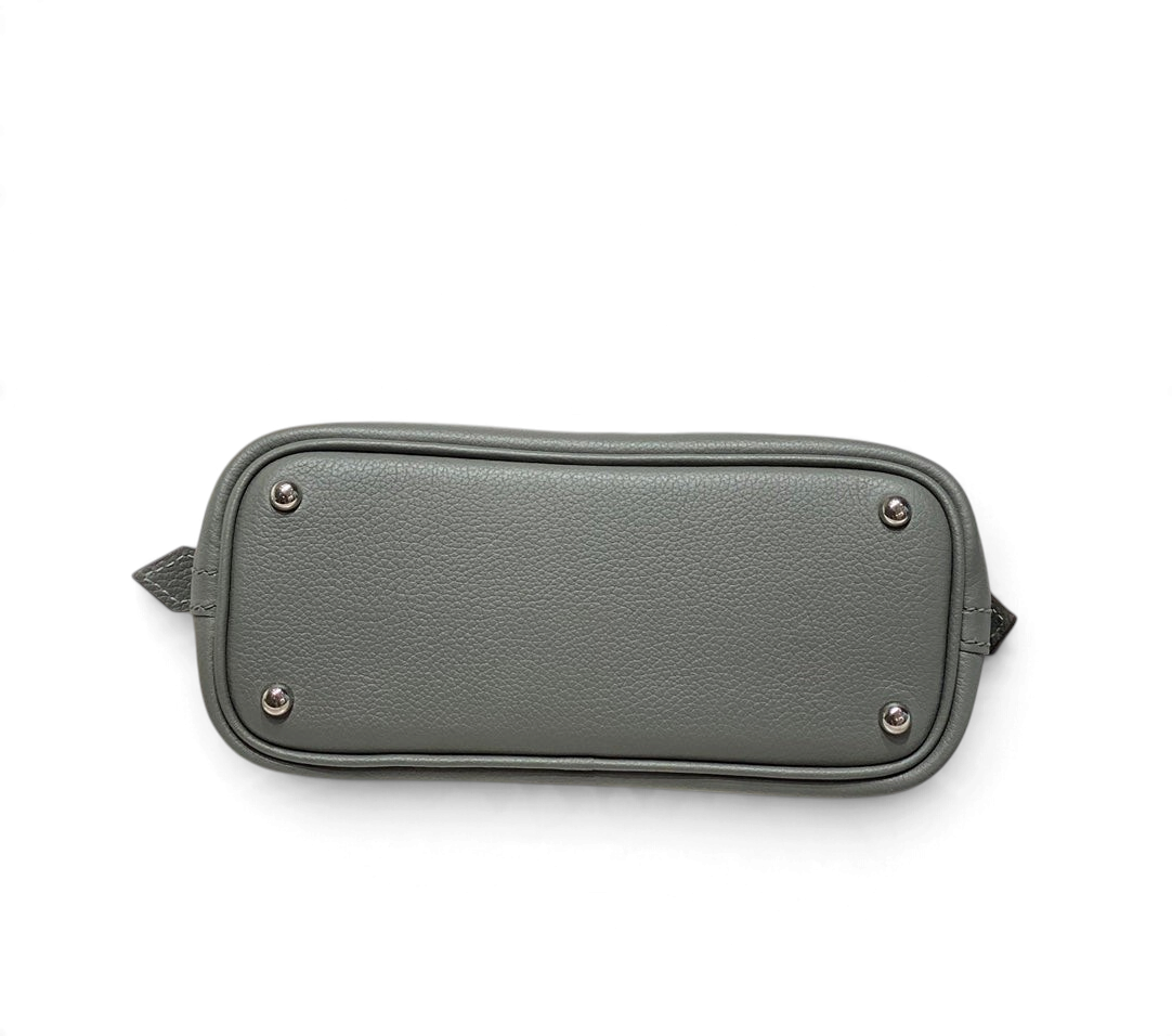 SWORD LUXURY Hermès Bolide Mini 19 çanta tabanı, gri damarlı deri ve koruyucu metal ayak detayları ile.