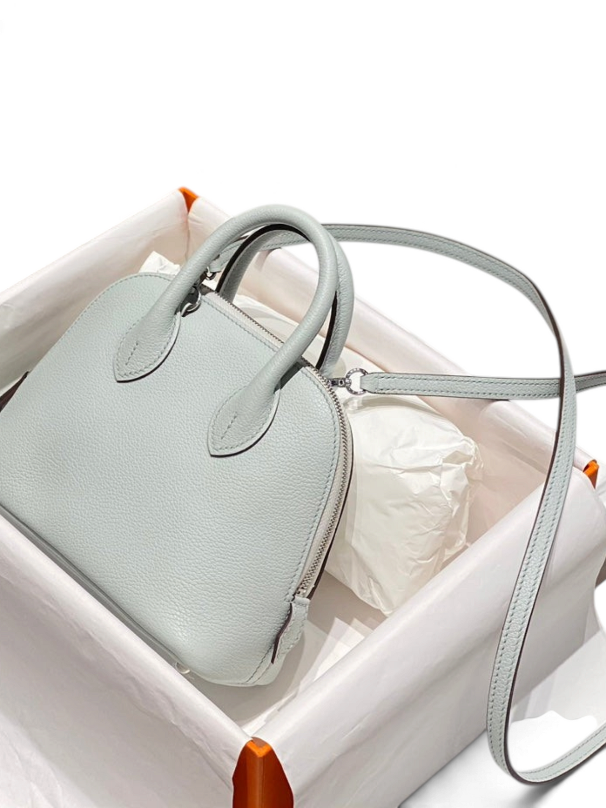 SWORD LUXURY Hermès Bolide Mini 19 çanta, açık mavi damarlı deri, yuvarlak silüet ve paladyum donanımlı kutusunda.