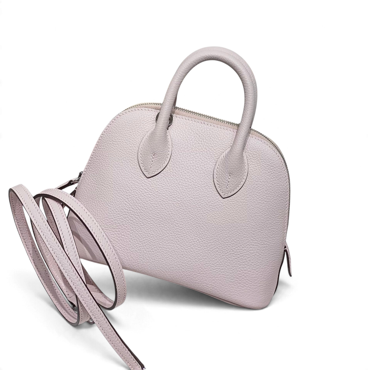 SWORD LUXURY marka, açık pembe renkli, taneli deri Hermès Bolide Mini 19 çanta, yuvarlak hatlı ve zarif tasarımlı.