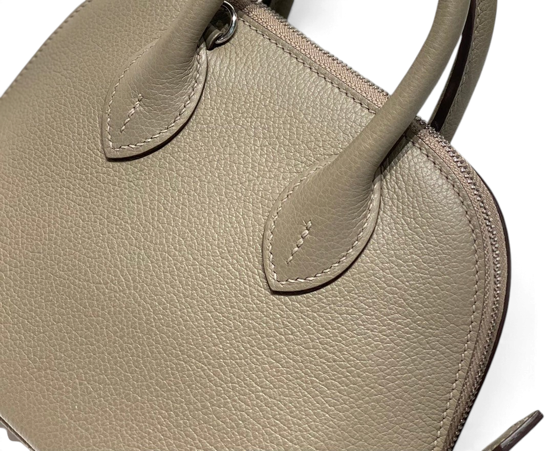 SWORD LUXURY Hermès Bolide Mini 19 çanta, bej renkli damarlı deri dokusu ve zarif dikiş detaylarıyla yakın çekim.