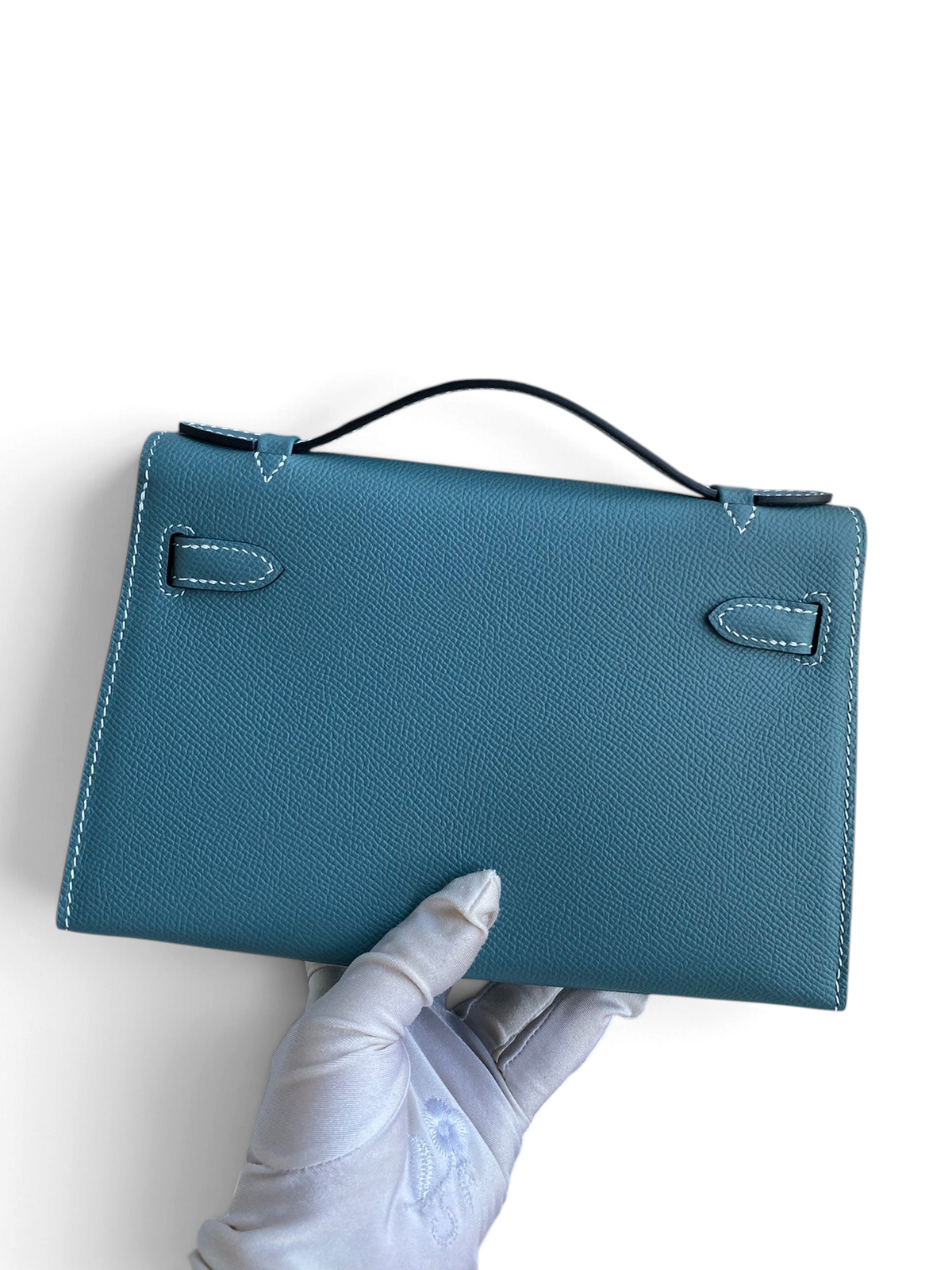 SWORD LUXURY marka, 22 cm mavi Epsom deri Mini Kelly çanta, beyaz dikiş detaylı ve tek üst saplı arka görünüm.