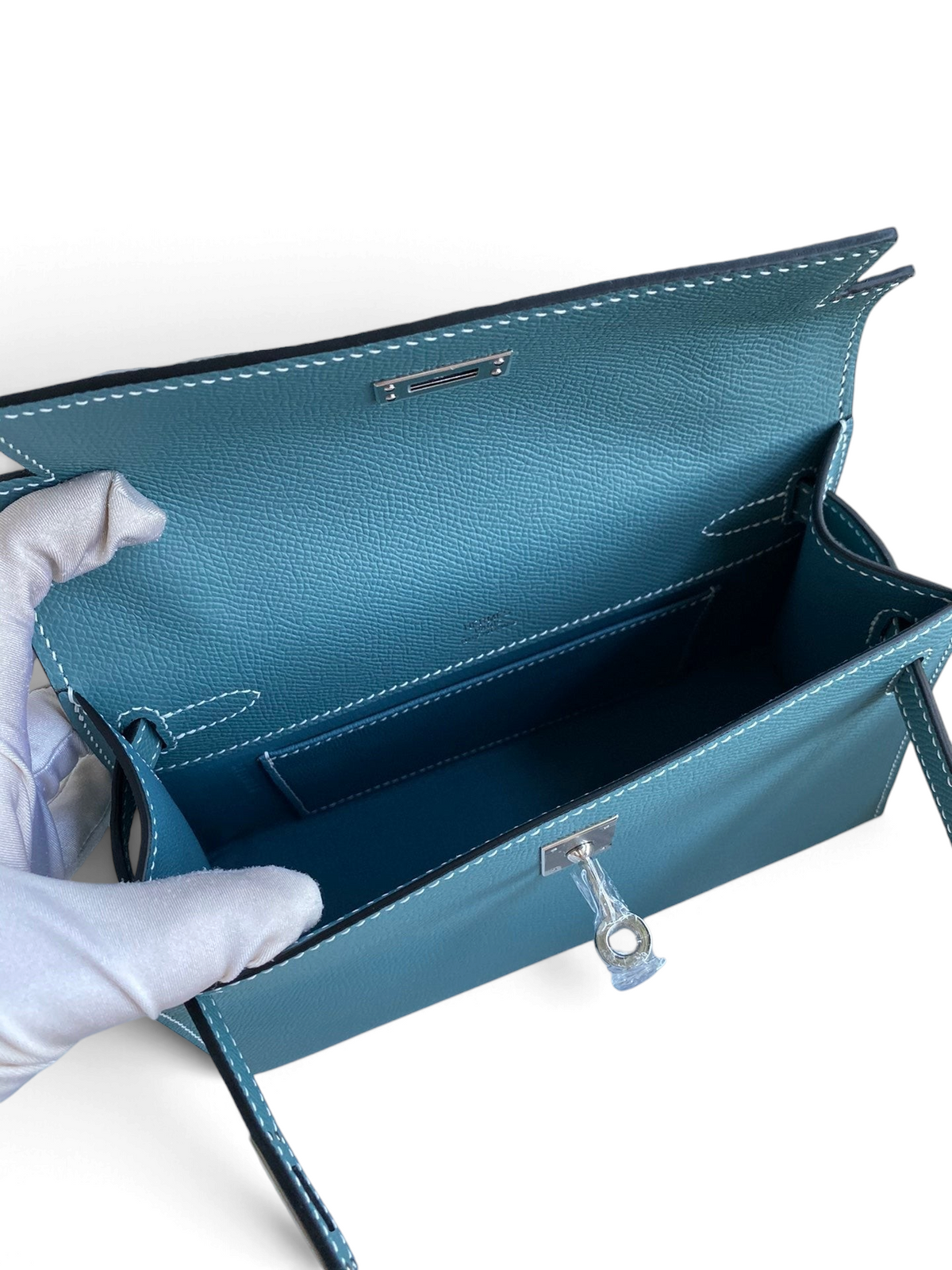 SWORD LUXURY marka, 22 cm mavi Epsom deri Mini Kelly çanta, iç kısmı ve metalik çevirmeli kilit detayı ile.