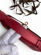 SWORD LUXURY marka, 22 cm boyutunda, kırmızı Epsom deri Mini Kelly çanta, üstten tutmalı ve altın detaylı kilitli.