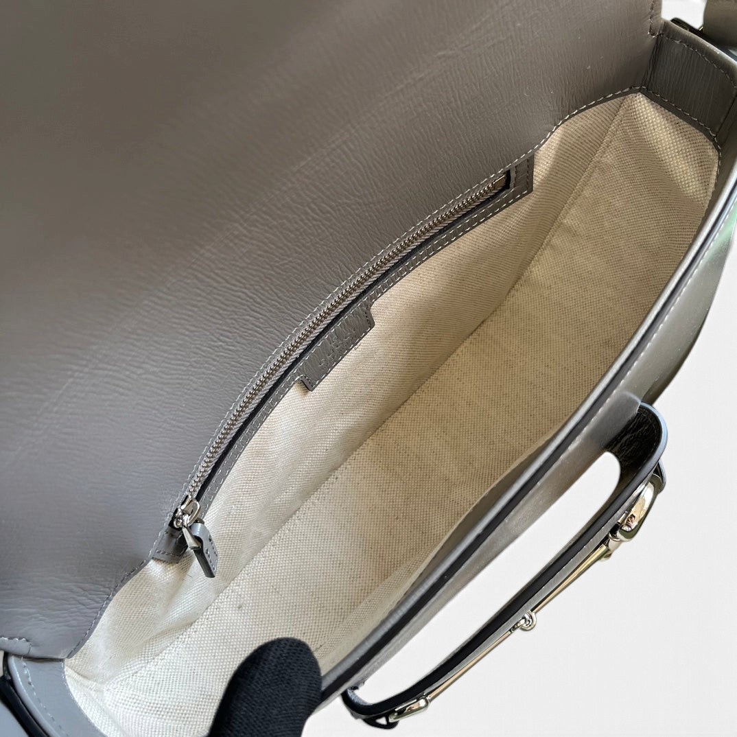 SWORD LUXURY Horsebit 1955 deri omuz çantasının iç kısmı, krem rengi astarı ve fermuarlı cebi ile detaylı görünümü.