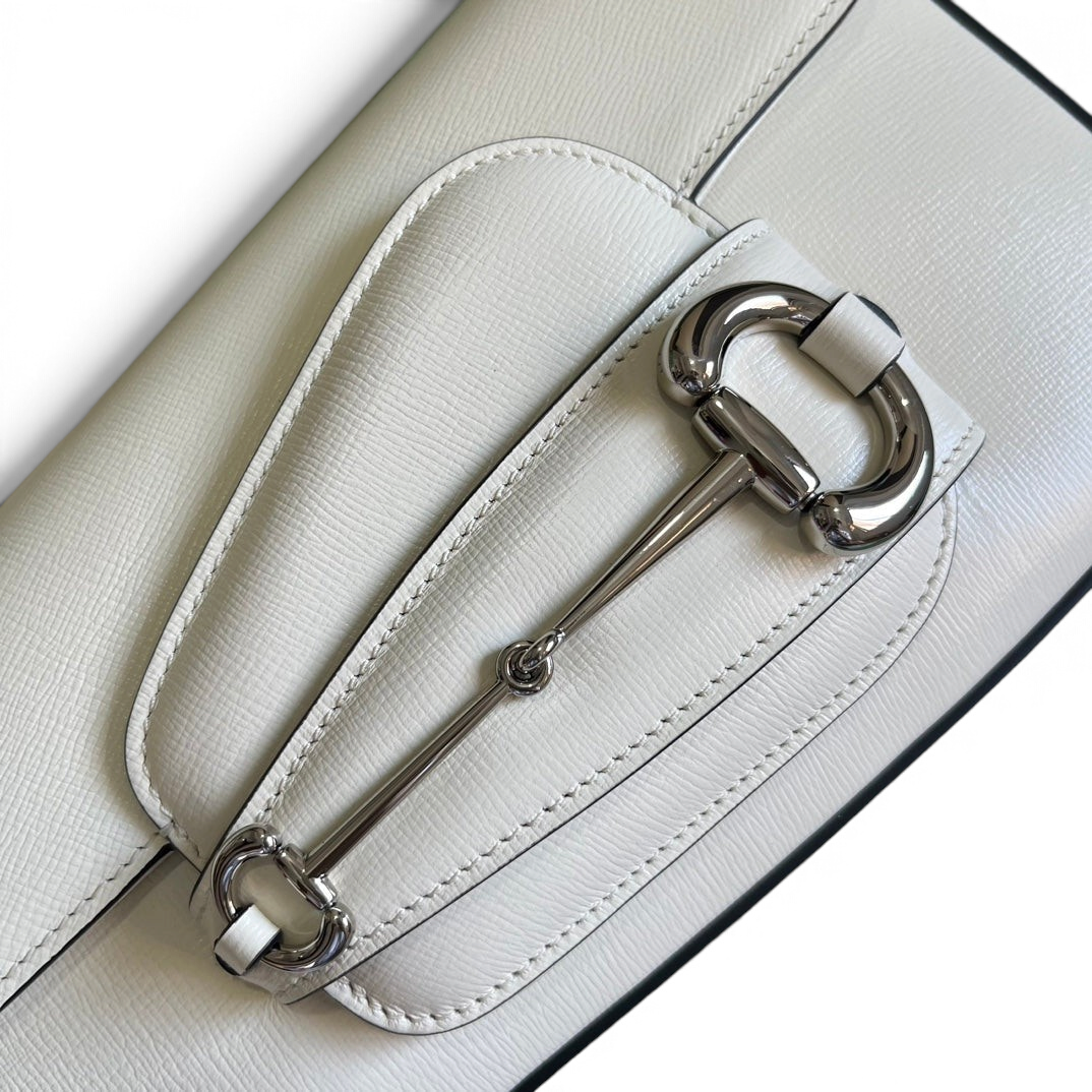 SWORD LUXURY Horsebit 1955 beyaz deri omuz çantası, ikonik metal detaylı kapaklı tasarım ve pürüzsüz doku.
