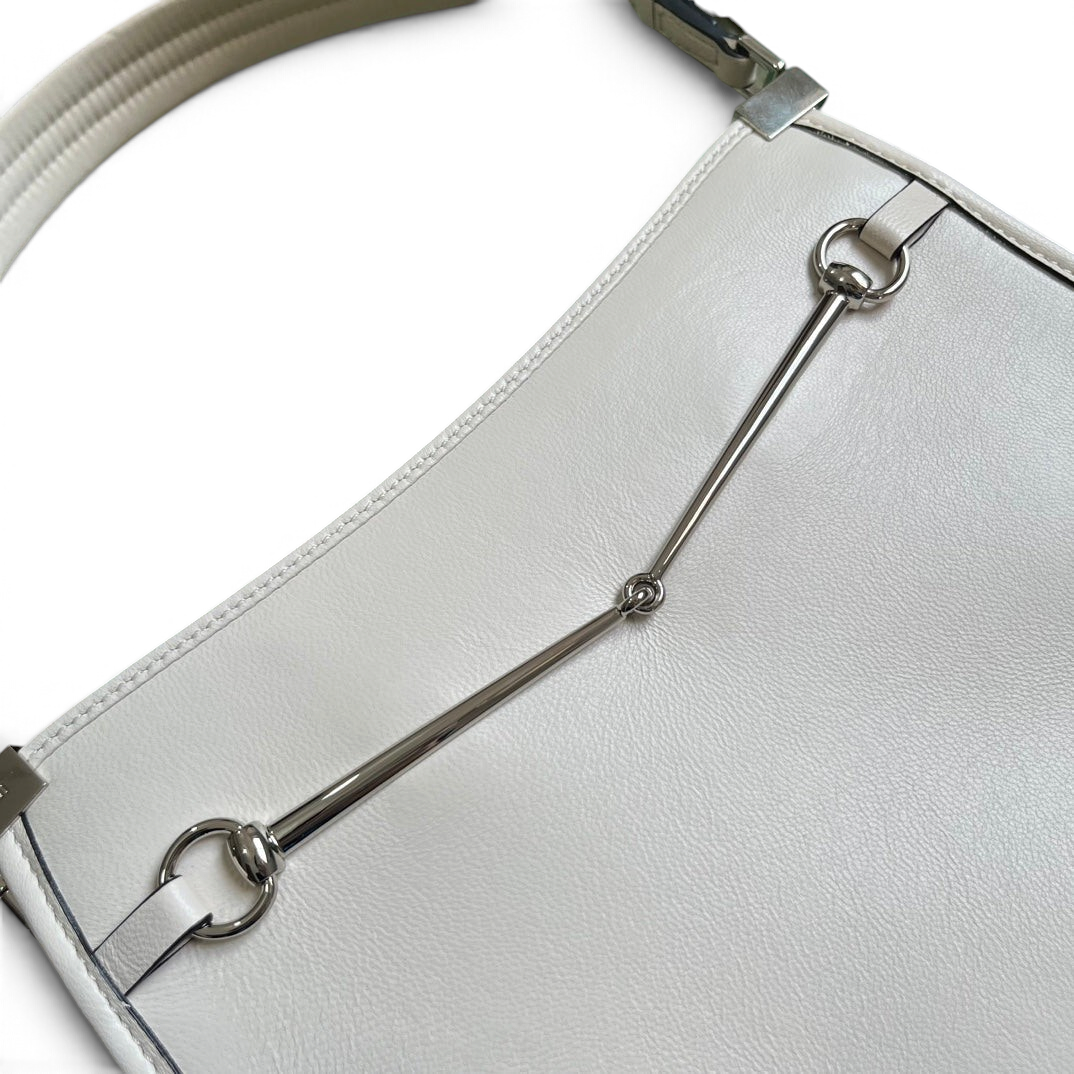 SWORD LUXURY beyaz deri Horsebit detaylı mini omuz çantası, gümüş tonlu metal aksesuarlara sahip zarif tasarım.