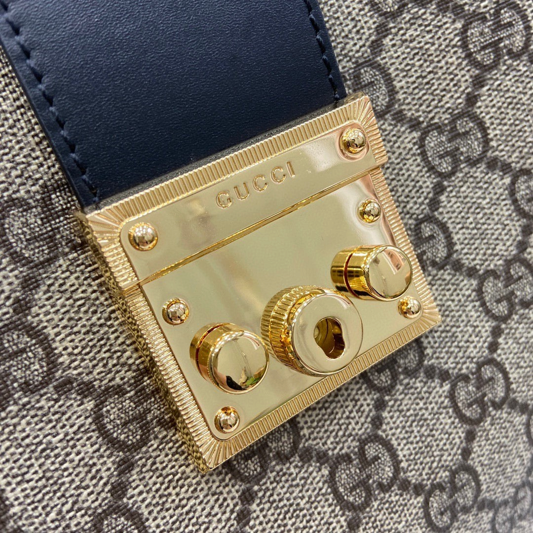 SWORD LUXURY Gucci Padlock omuz çantası için altın tonlu metal kilit detayı ve lacivert deri kayış.