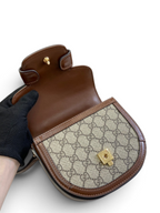 SWORD LUXURY Horsebit 1955 mini çanta, ikonik GG desenli kanvas ve kahverengi deri detaylı, altın tonlu donanımlı.