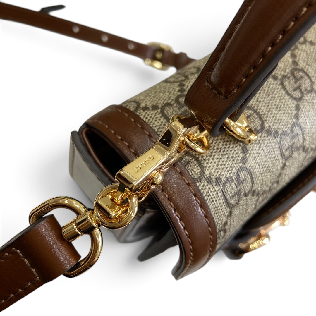 SWORD LUXURY Horsebit 1955 mini çanta, kahverengi deri detaylı ve altın tonlu metal askı klipsli monogram kanvas tasarım.