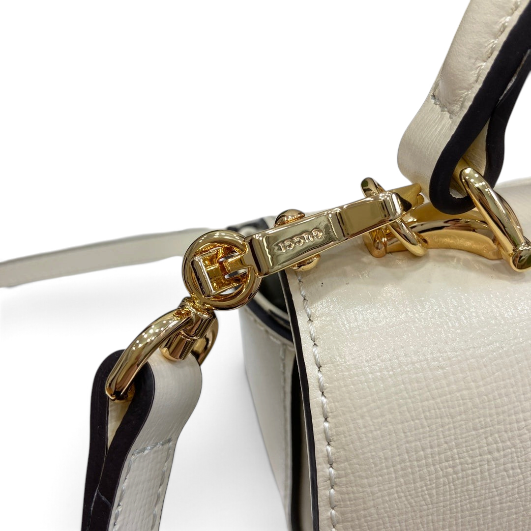 SWORD LUXURY Horsebit 1955 mini çanta, altın tonlu metal detaylı beyaz deri omuz askısı bağlantısı.
