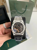 Luxury watch held by a hand with a green box in the background