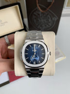 Silver watch with blue face on a display stand, with a blurred background