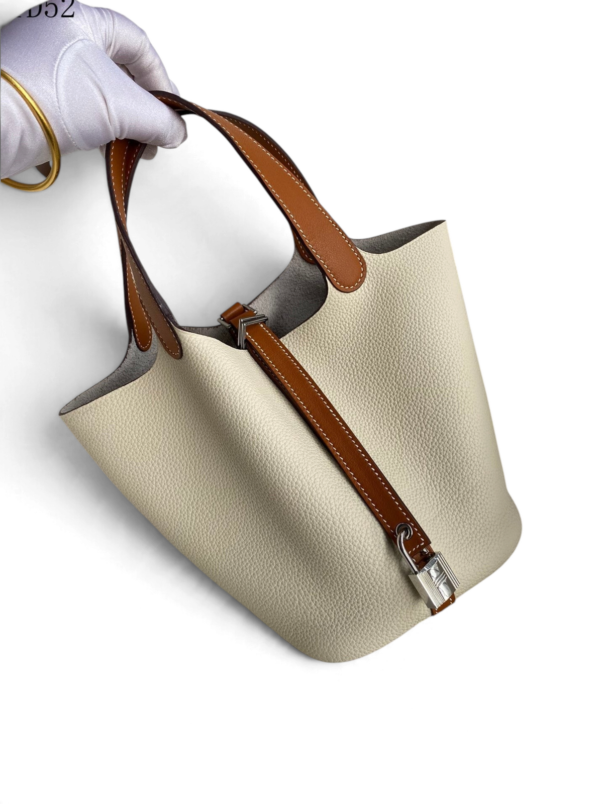 SWORD LUXURY Picotin Lock 18 bucket çanta, krem rengi Togo deri gövde ve altın kahverengi deri sap detaylı.