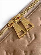 SWORD LUXURY Coussin Hobo MM çanta, kabartmalı monogram desenli çikolata kahvesi deri ve altın tonlu fermuar detayı.