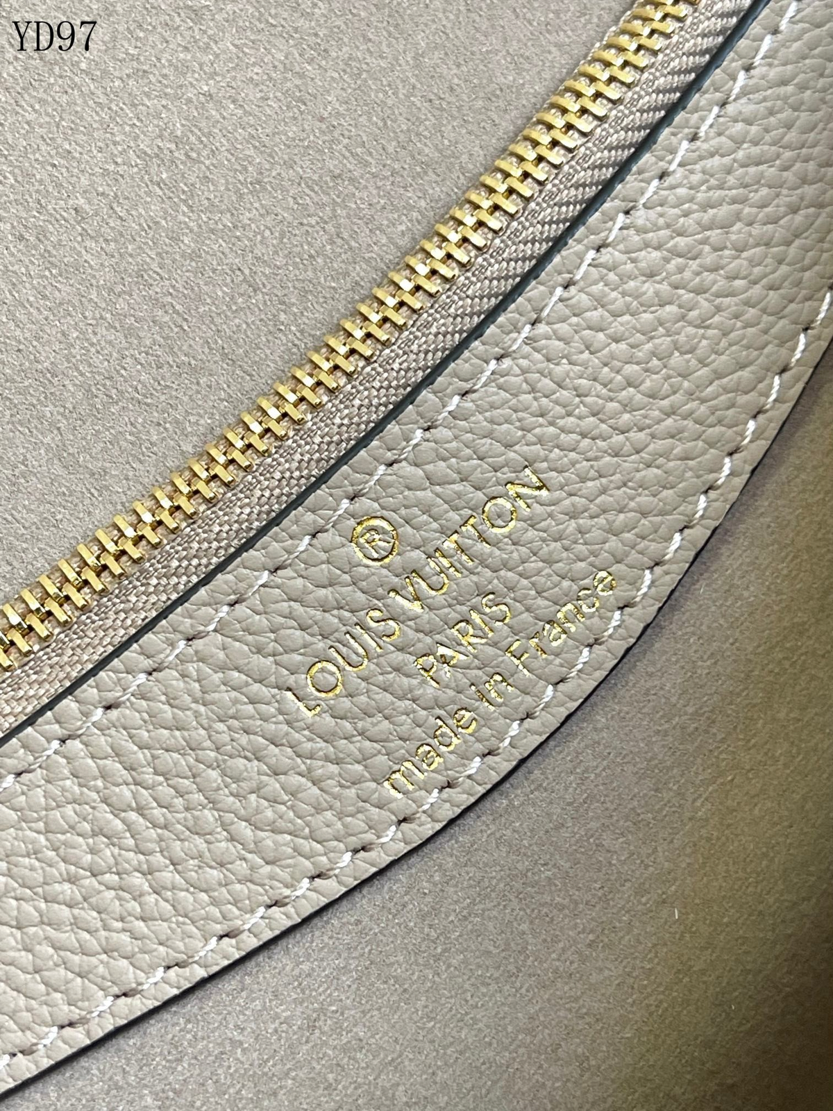 SWORD LUXURY Louis Vuitton Diane çanta, krem rengi Monogram Empreinte deri üzerinde altın rengi kabartmalı logo detayı.