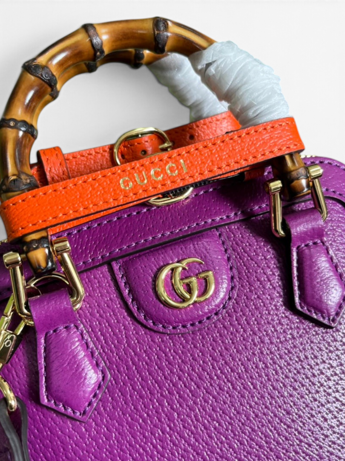 SWORD LUXURY imzalı, mor deri Gucci Diana çanta, bambu saplı, turuncu deri detaylı ve altın rengi GG logolu.