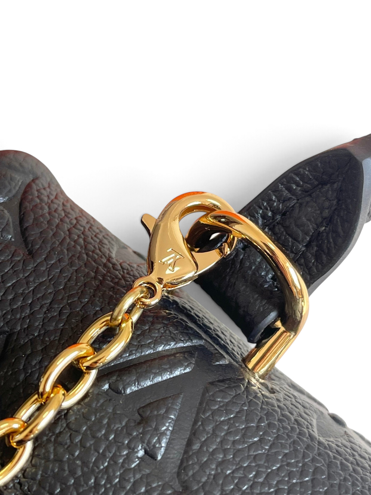 SWORD LUXURY Madeleine Nano çanta, siyah monogram kabartmalı deri ve altın tonlu zincir detaylı yakın çekim.
