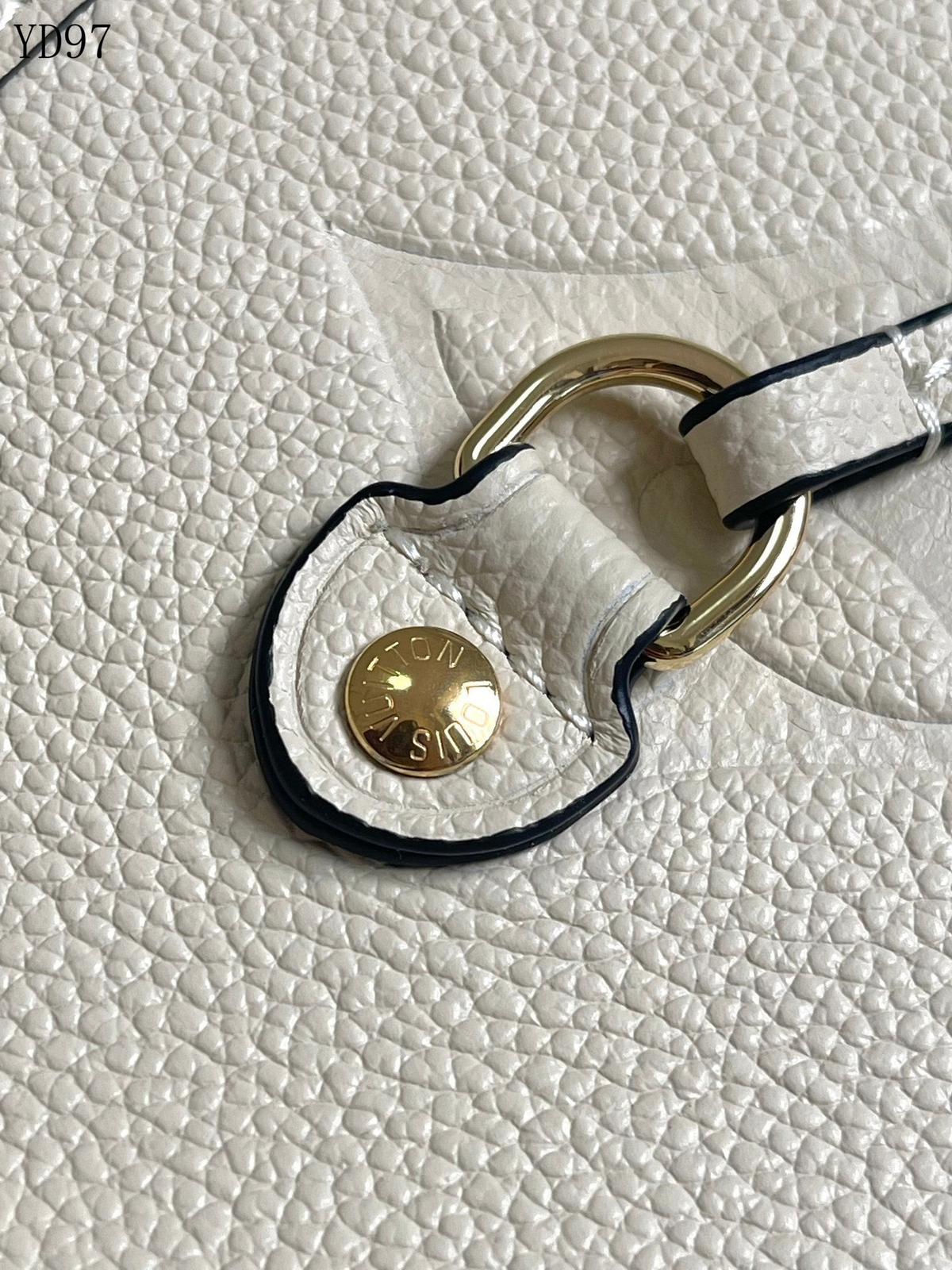 SWORD LUXURY krem rengi deri çanta detayı, altın tonlu metal donanım ve marka logolu düğme ile.