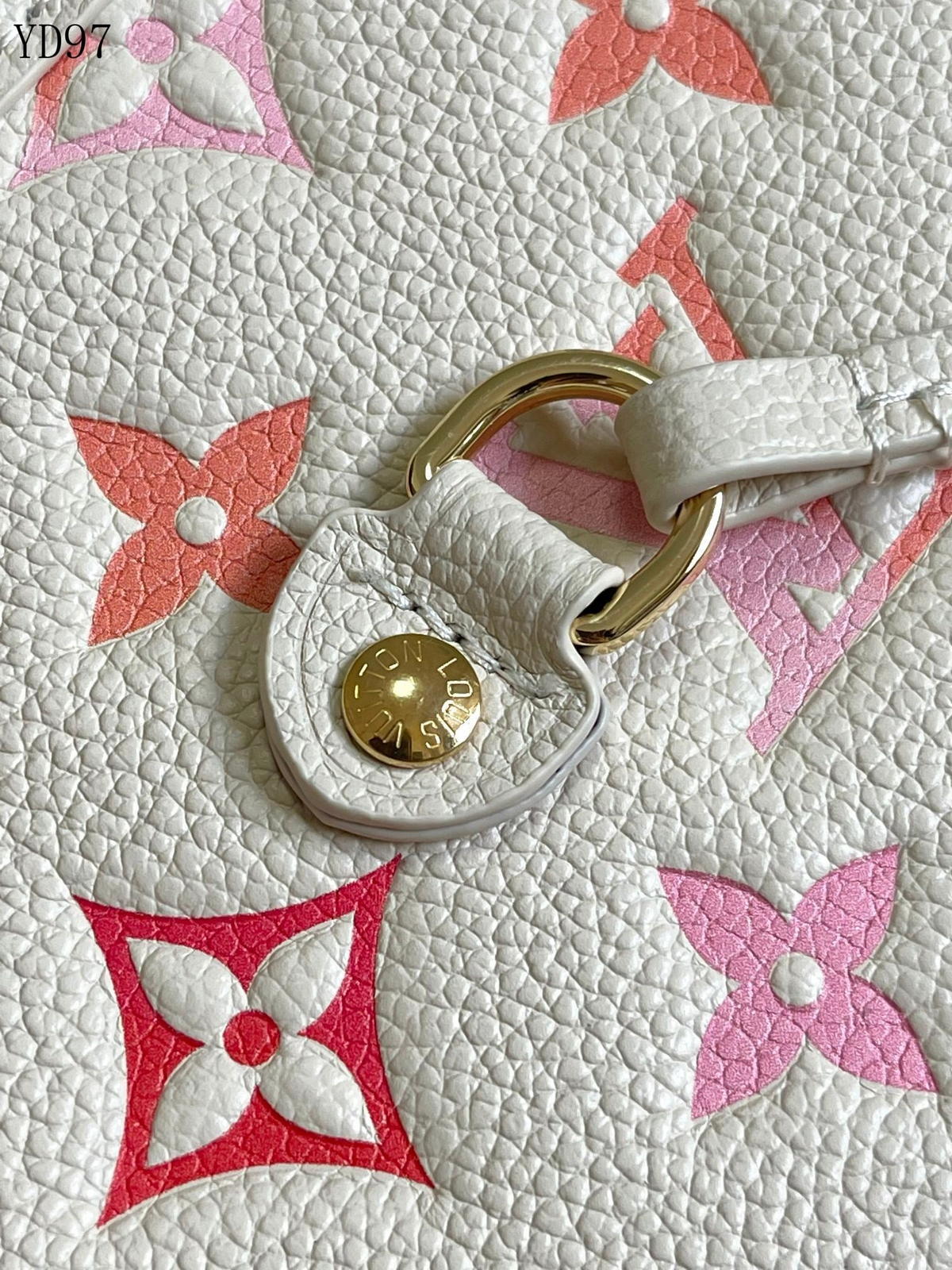 SWORD LUXURY krem ve turuncu monogram desenli kanvas çanta detayı, altın tonlu metal donanım ve deri süslemeler.