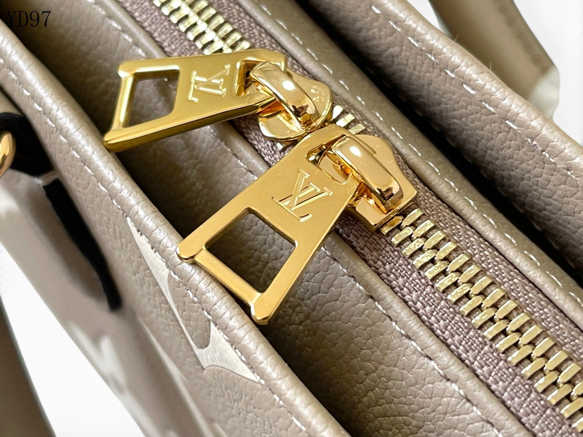 SWORD LUXURY Louis Vuitton OnTheGo East West çanta üzerinde altın tonlu LV işlemeli fermuar detayı
