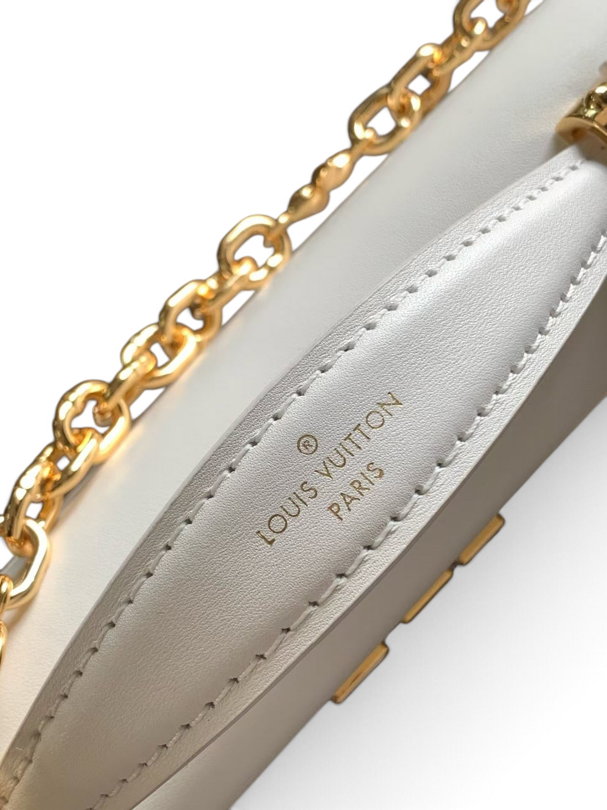 SWORD LUXURY beyaz deri Capucines cüzdan çanta, altın tonlu zincir askı ve Louis Vuitton kabartmalı detaylar.