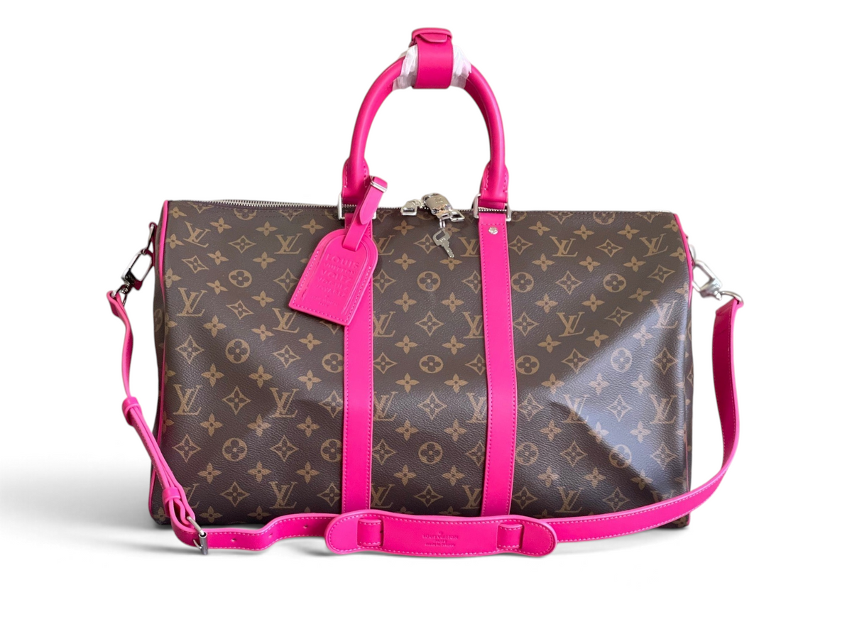 SWORD LUXURY Louis Vuitton Keepall Bandoulière 50 çanta, ikonik monogram kanvas ve canlı pembe deri detaylı seyahat çantası.