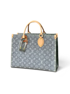 SWORD LUXURY gri monogram desenli denim kanvas OnTheGo MM çanta, doğal deri saplar ve altın tonlu metal detaylar.