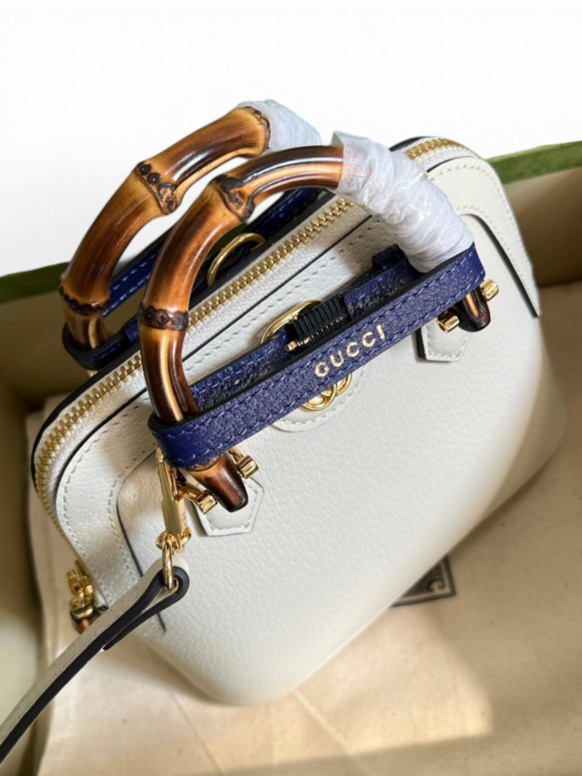 SWORD LUXURY beyaz deri Gucci Diana çanta, ikonik bambu saplar ve mor deri detaylarla kutu içerisinde sunuluyor.