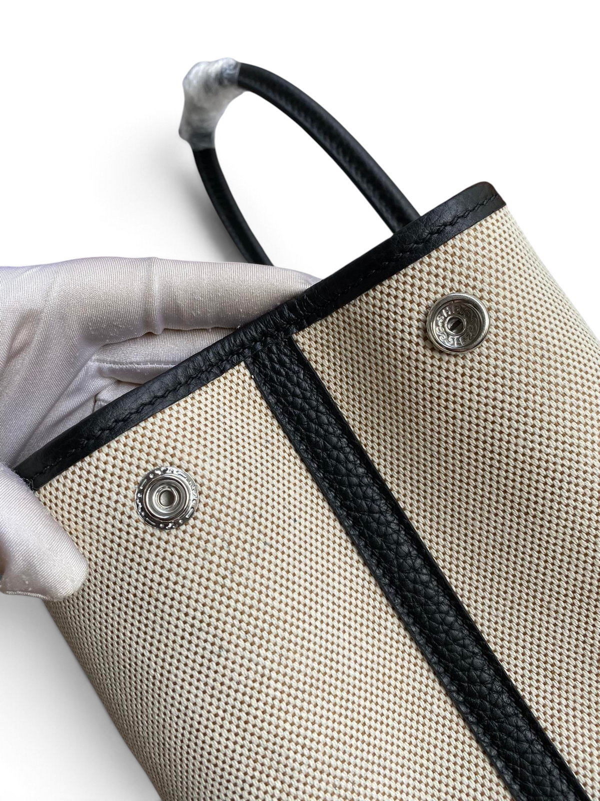 SWORD LUXURY Hermès Garden Party 30 çanta, bej kanvas ve siyah deri detaylı, metal çıtçıtlı tasarım detayı.