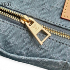 SWORD LUXURY Monogram Denim OnTheGo MM çanta üzerinde altın tonlu fermuar detayı ve gri monogram desenli denim kumaş.