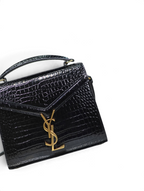 SWORD LUXURY siyah timsah derisi görünümlü Cassandra mini çanta, altın tonlu YSL monogram detaylı ve zarif saplı.