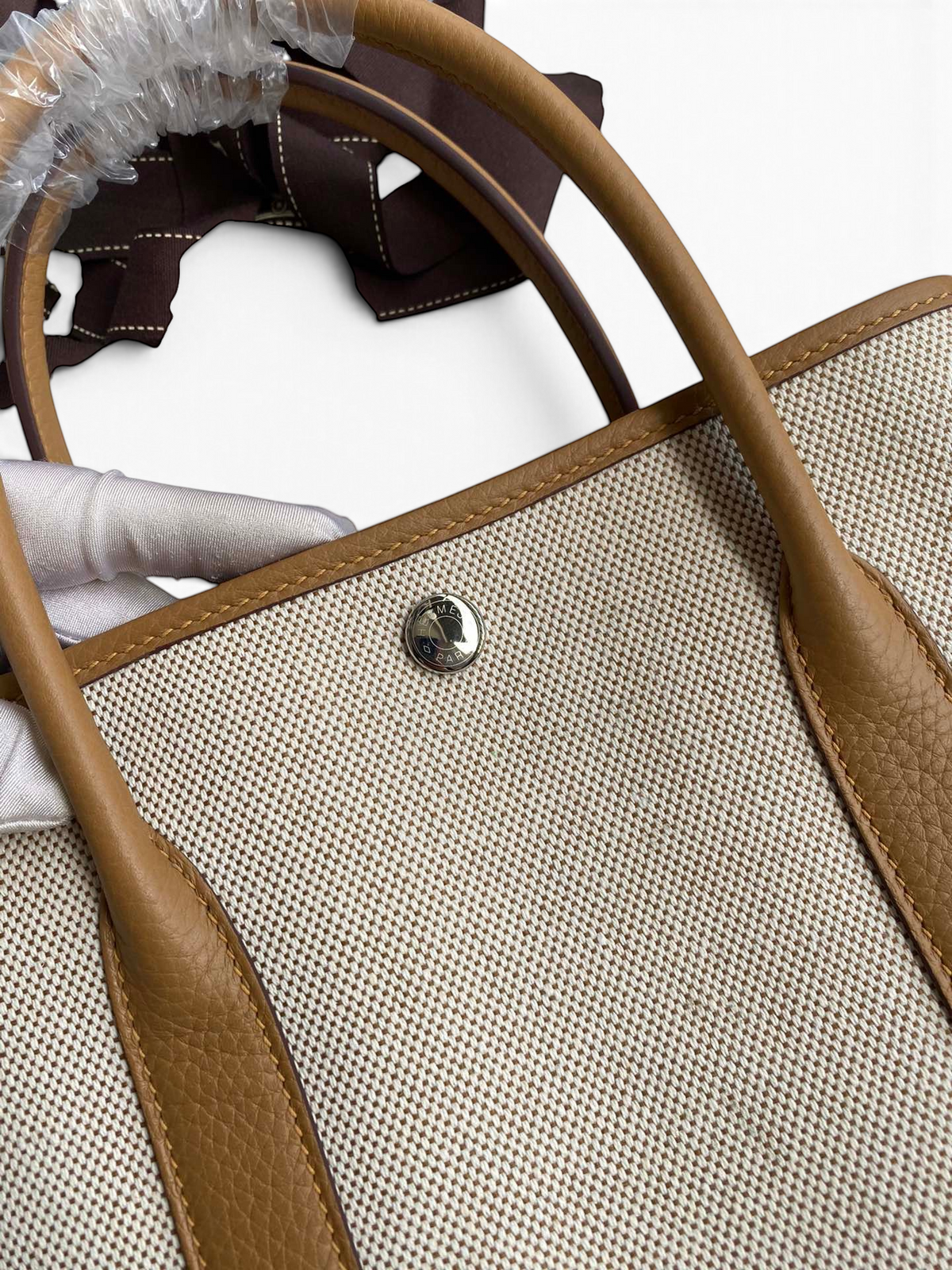 SWORD LUXURY Hermès Garden Party 30 çanta, bej kanvas ve taba rengi deri detaylı, metal çıtçıtlı tasarım.