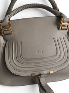 SWORD LUXURY Chloé Marcie çanta, gri damarlı deri, altın tonlu donanım ve ikonik kavisli dikiş detaylarına sahip.