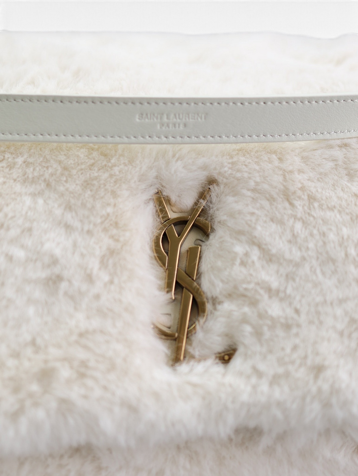 SWORD LUXURY beyaz suni kürk çanta, altın tonlu metal amblemi ve şık deri detaylarıyla kışlık tasarım.