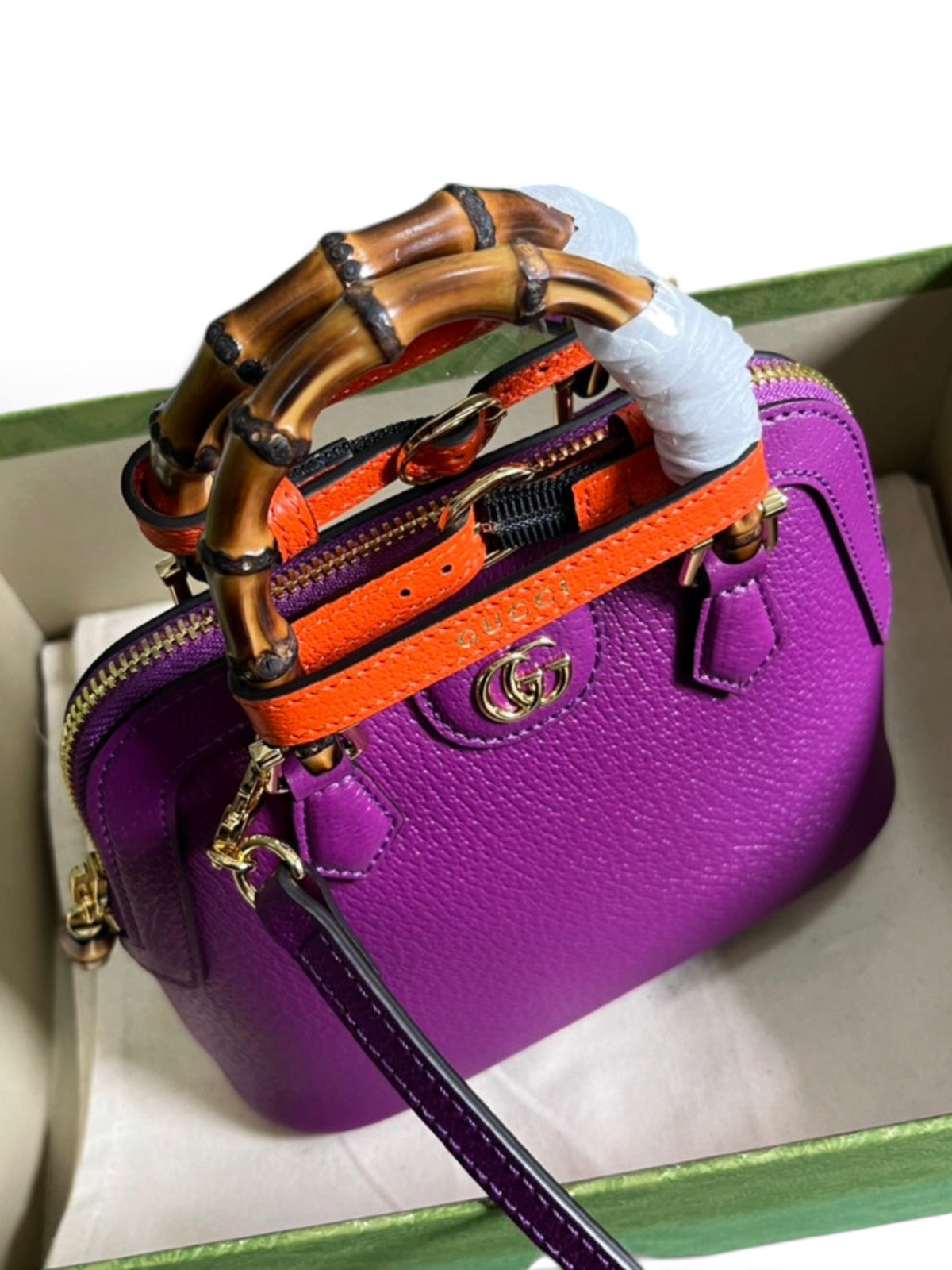 SWORD LUXURY mor deri Gucci Diana çanta, bambu saplı, turuncu detaylı ve altın rengi GG logolu, kutu içinde.