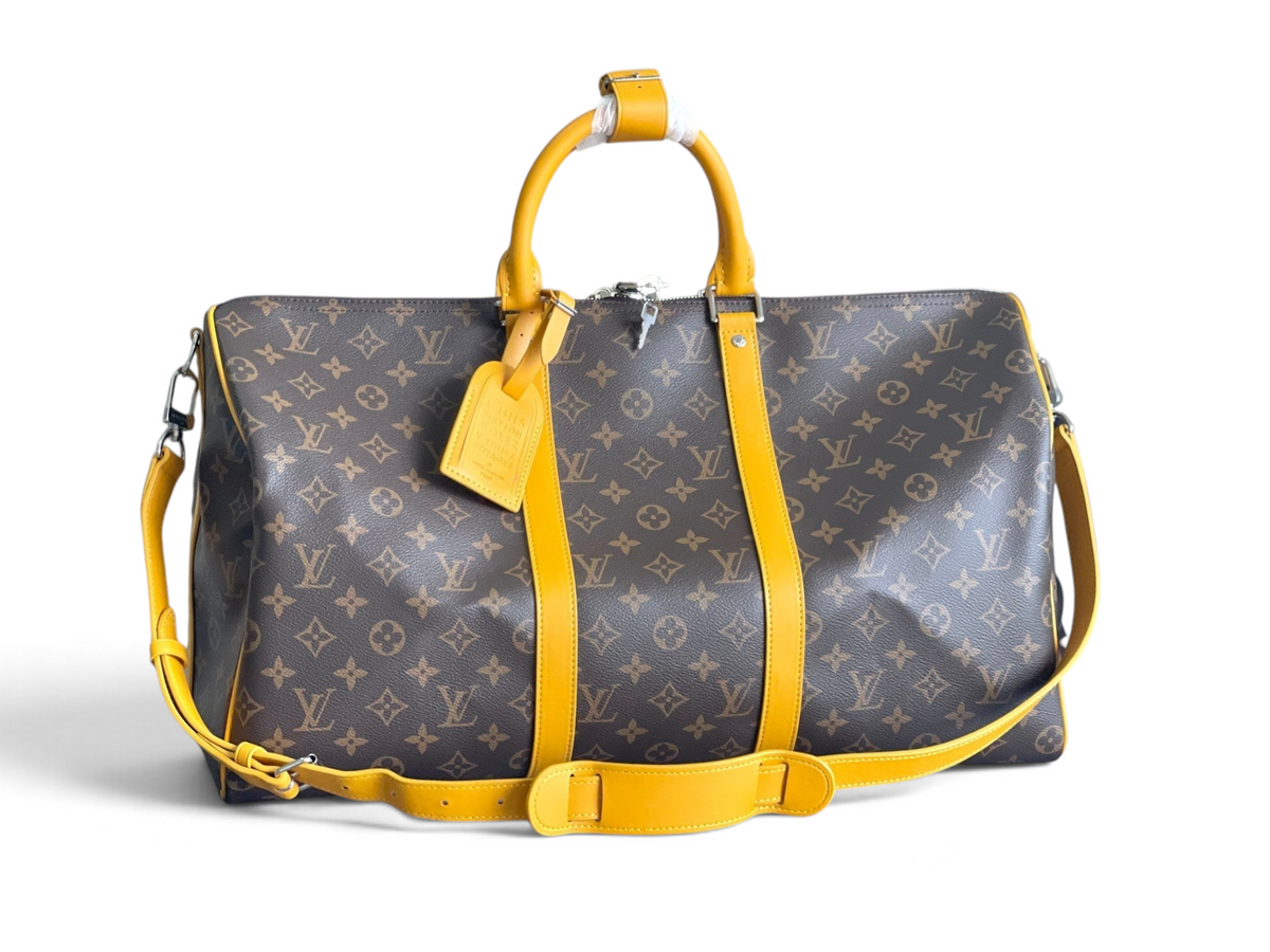 SWORD LUXURY Louis Vuitton Keepall Bandoulière 50 seyahat çantası, ikonik monogram kanvas ve canlı sarı deri detaylı.