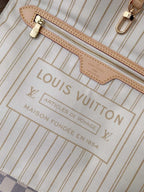SWORD LUXURY Neverfull MM çanta iç detayı, bej çizgili astar, deri fermuarlı cep ve altın rengi metal aksesuarlar.