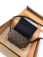 SWORD LUXURY Steamer Mini çanta, kahverengi monogram kanvas, deri detaylar ve siyah askı ile kutusunda sunuluyor.