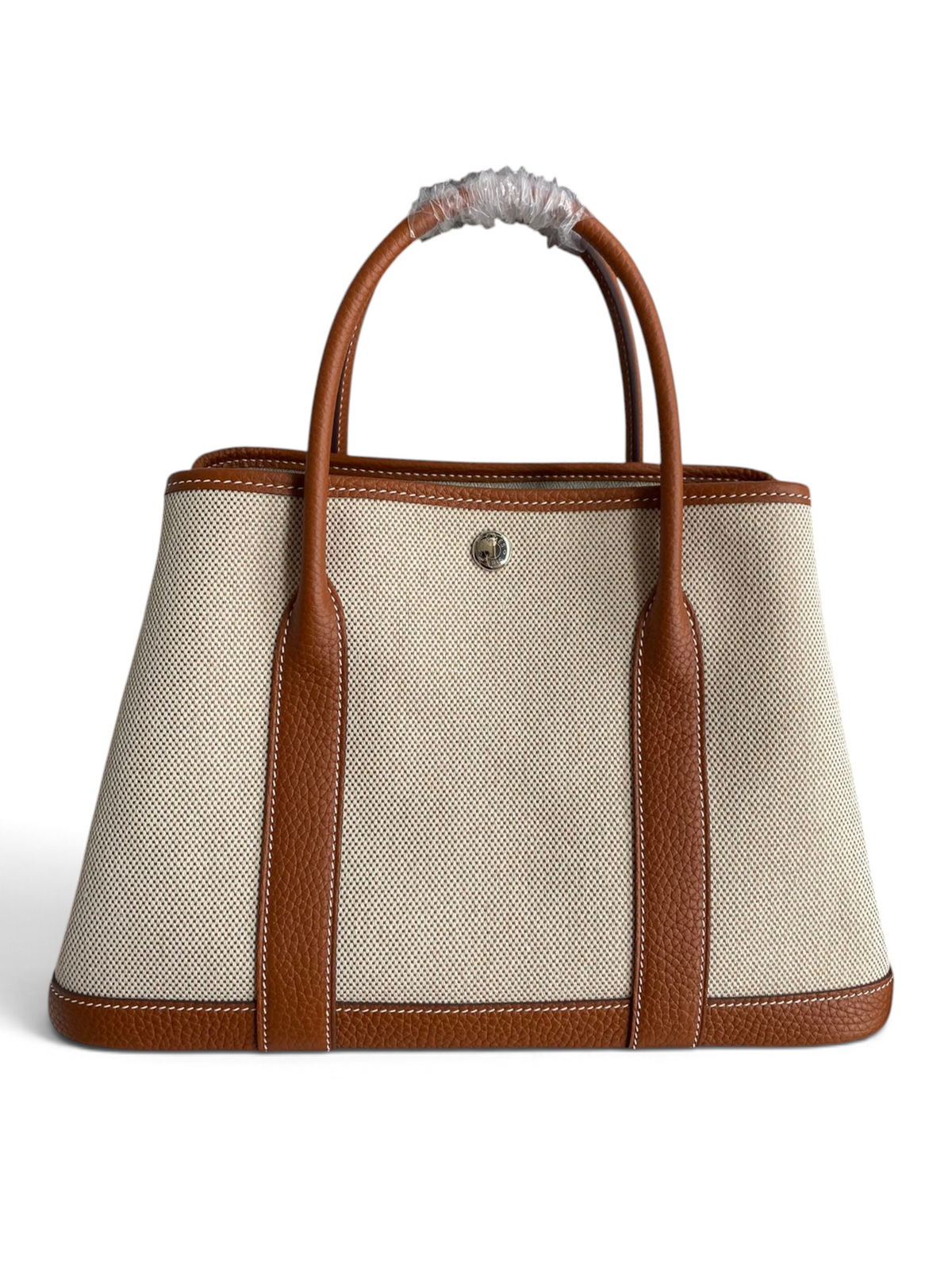 SWORD LUXURY marka bej kanvas ve taba deri detaylı Hermès Garden Party 30 çanta, kutusunda sunuluyor.