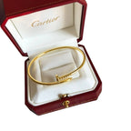 Gold bracelet in a Cartier box on a white background