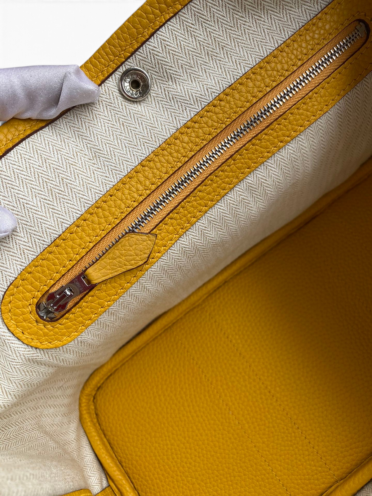 SWORD LUXURY Hermès Garden Party 30 çanta içi, sarı deri detaylı ve fermuarlı bölmeli krem rengi kanvas astar.