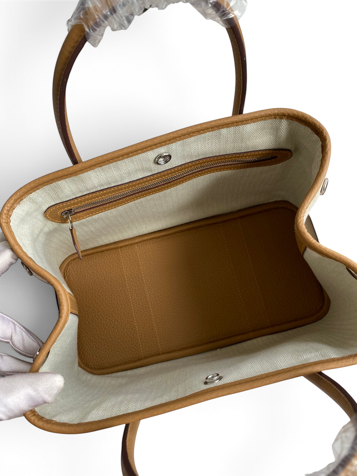 SWORD LUXURY Hermès Garden Party 30 çanta, bej kanvas iç astarı ve taba rengi deri tabanı ile üstten görünüm.