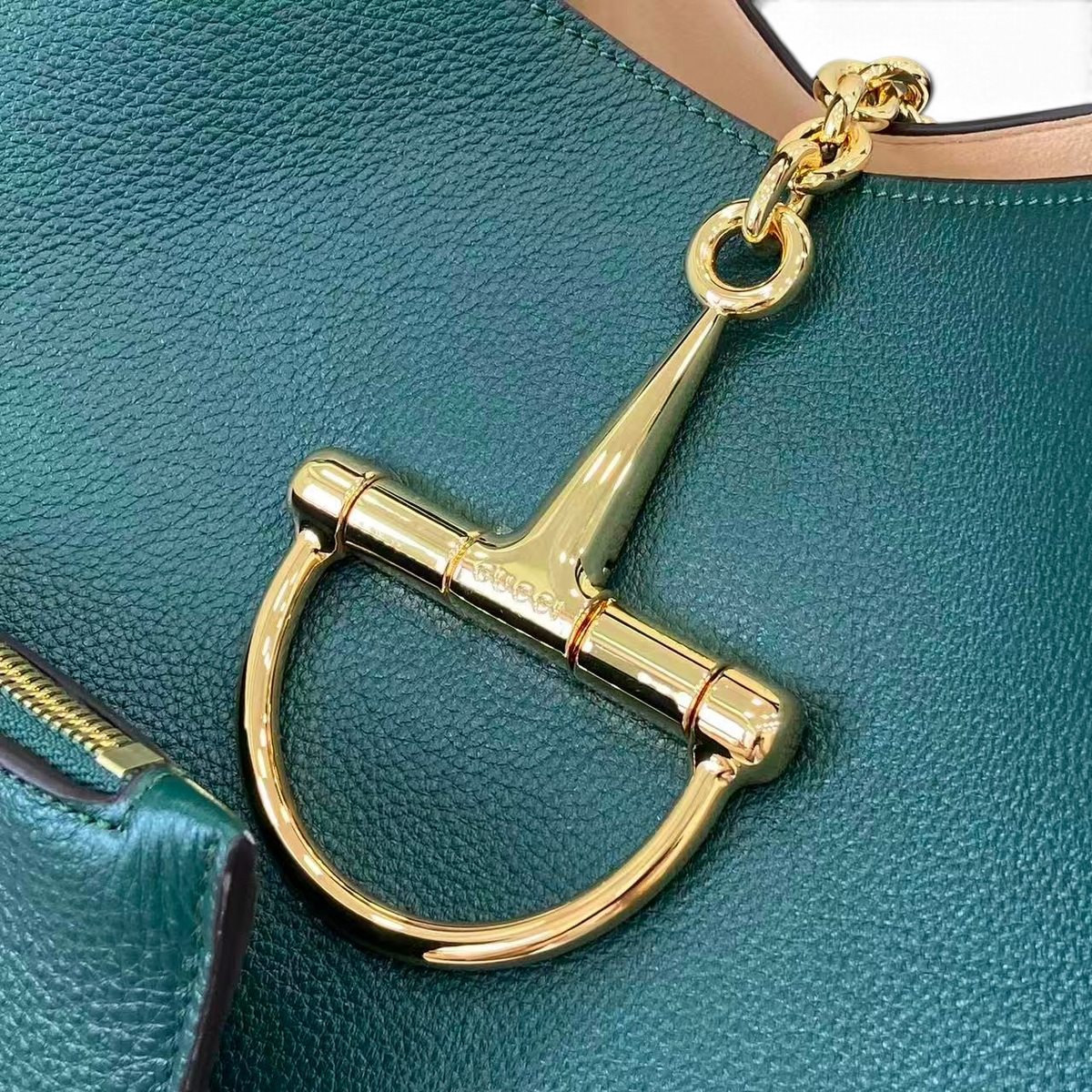 SWORD LUXURY koyu yeşil damarlı deri omuz çantası, altın rengi metal at gemi detayı ile yakın çekim