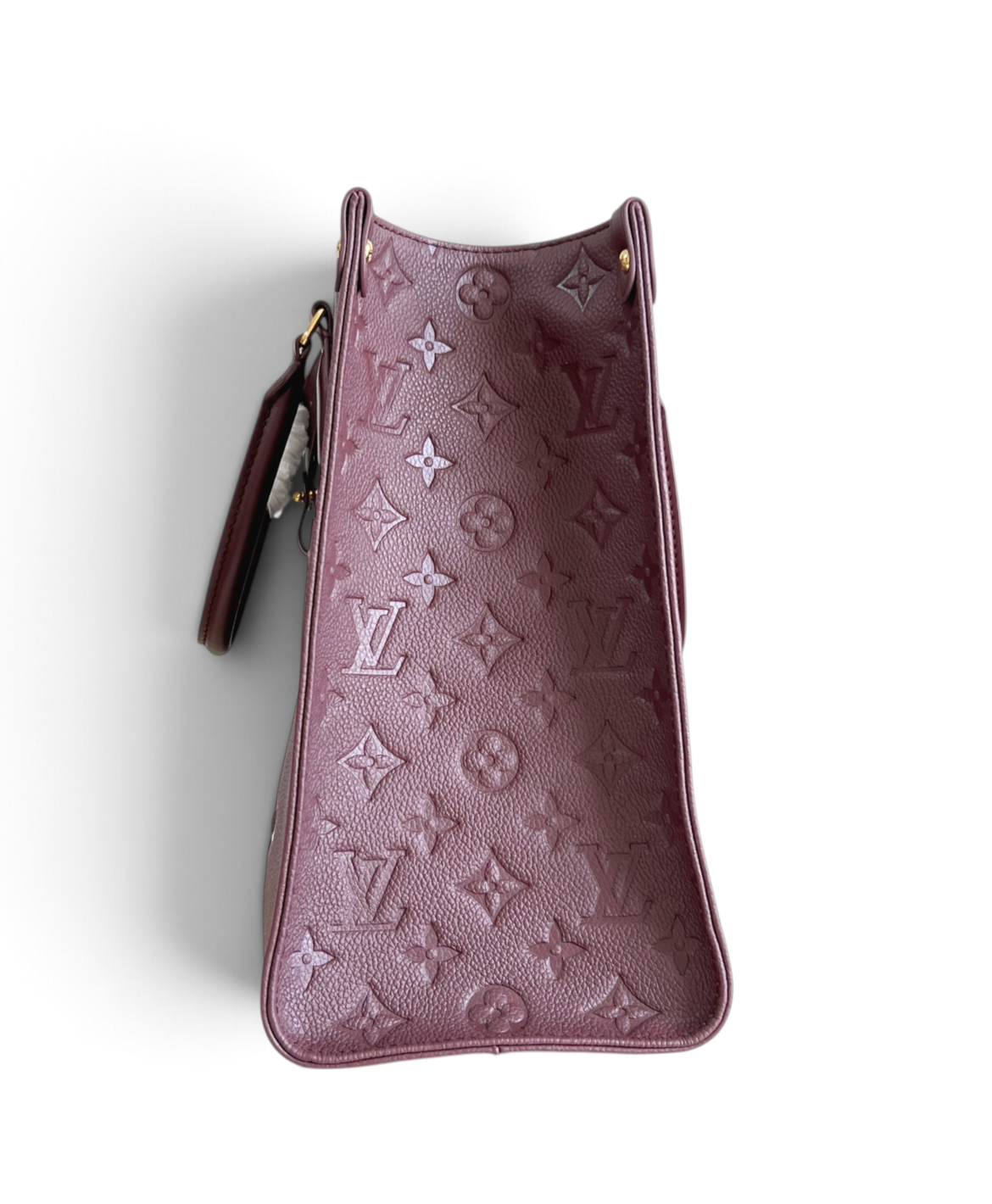 SWORD LUXURY Louis Vuitton OnTheGo MM çanta, kabartmalı Monogram desenli lüks mürdüm rengi deri dokusu ile yan görünüm.