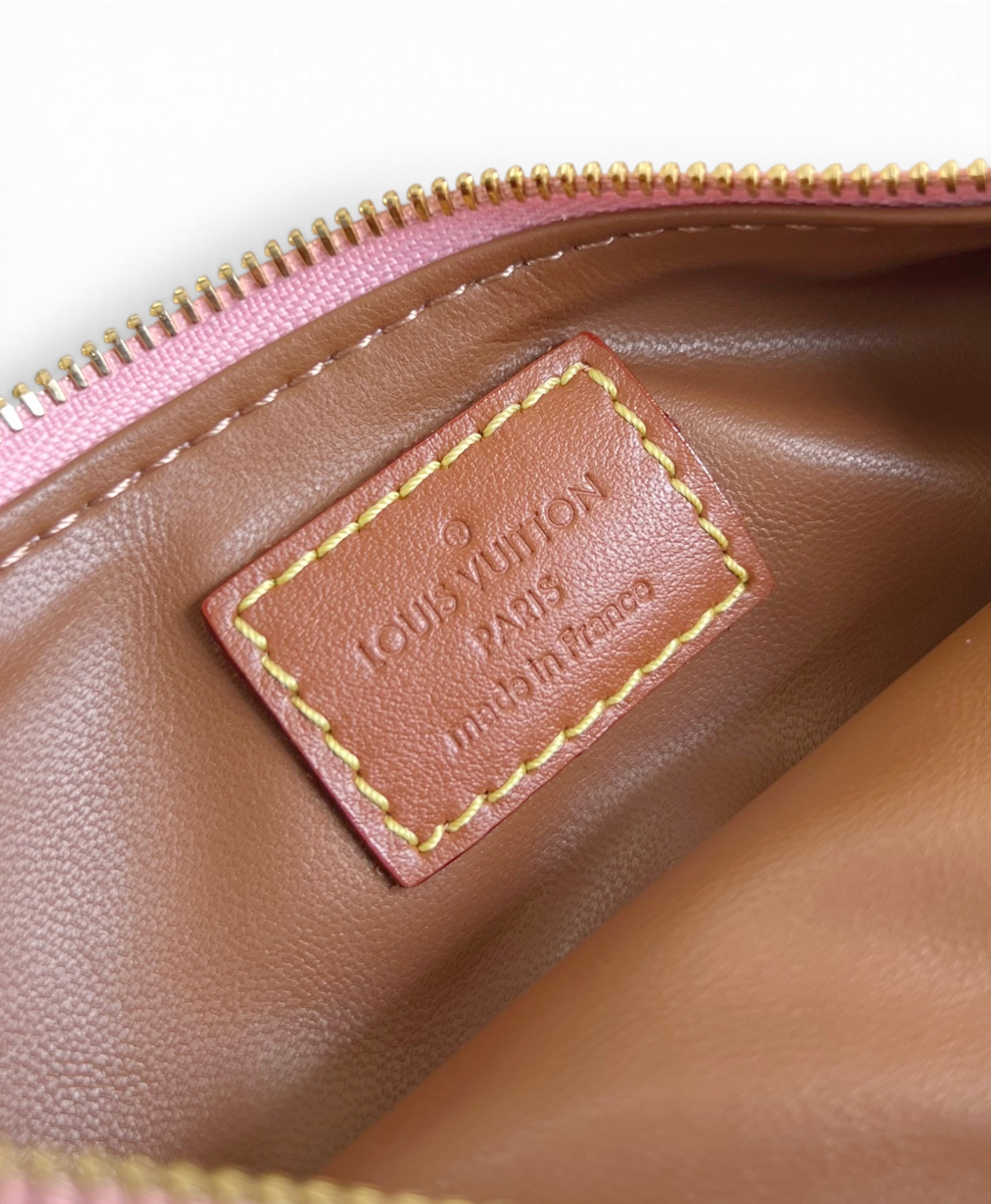 SWORD LUXURY Louis Vuitton Speedy Bandoulière 30 çanta iç kısmındaki deri logo etiketi ve pembe fermuar detayı.
