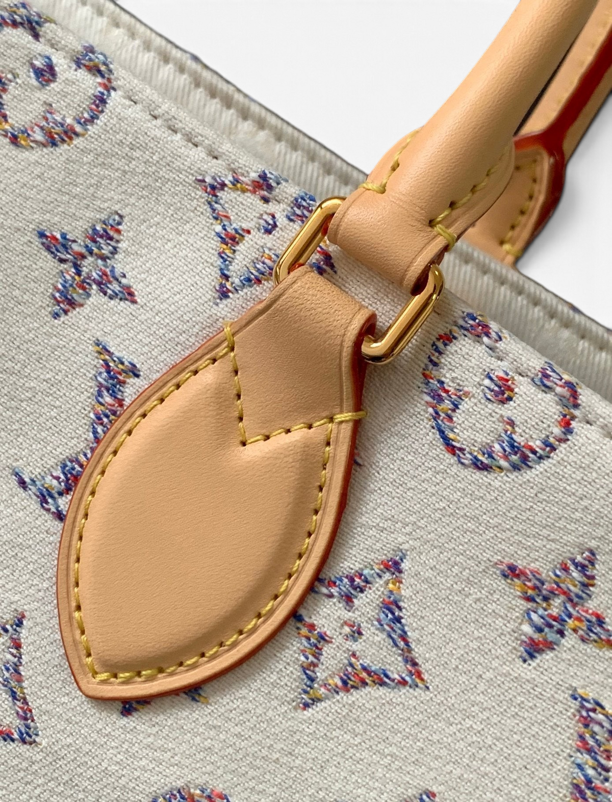 SWORD LUXURY Louis Vuitton OnTheGo MM çanta, çok renkli monogram desenli kanvas ve doğal deri detaylı sap bağlantısı.