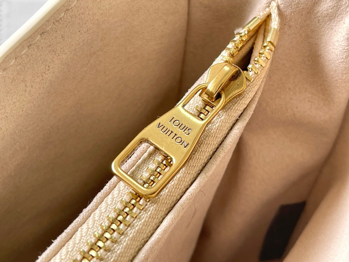 SWORD LUXURY Low Key omuz çantası iç kısmında altın tonlu Louis Vuitton logolu fermuar detayı ve süet benzeri astar.