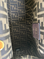 SWORD LUXURY Fendi First çanta içi, ikonik kahverengi monogram kumaş astar ve Fendi marka etiketi detayları.