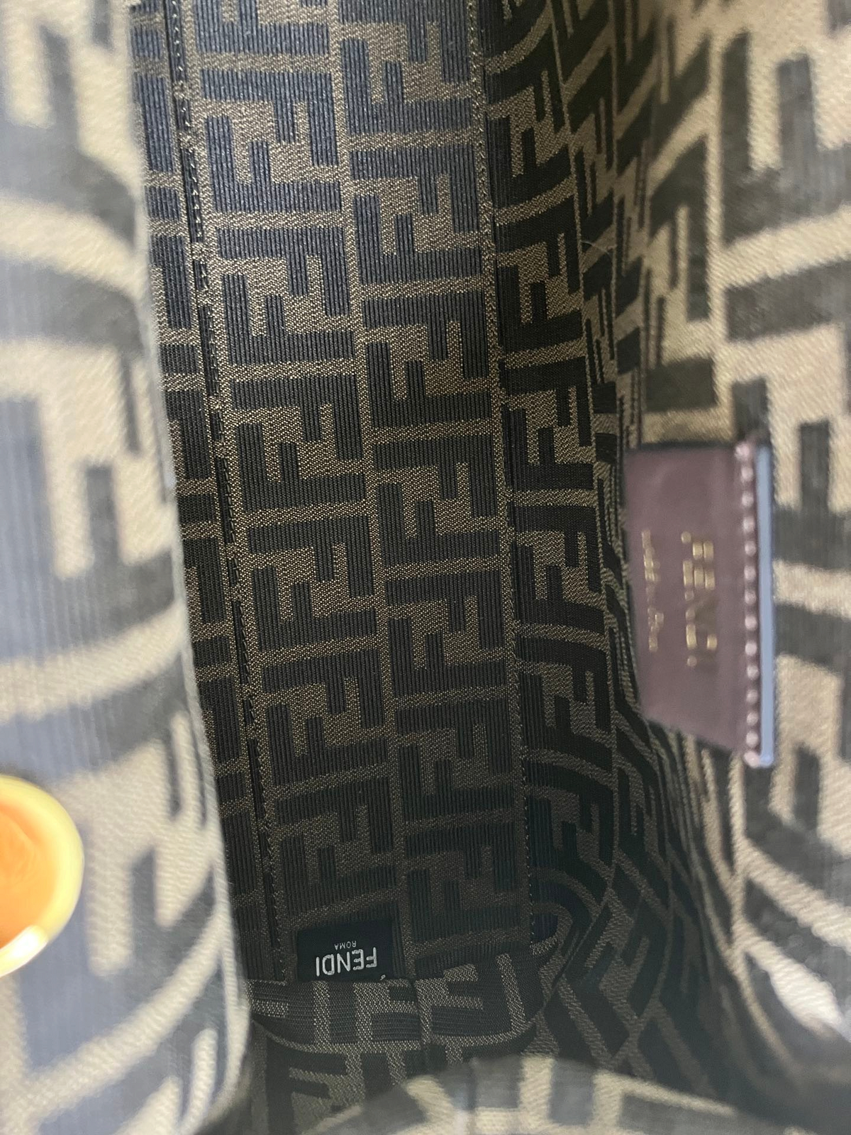 SWORD LUXURY Fendi First çanta içi, ikonik kahverengi monogram kumaş astar ve Fendi marka etiketi detayları.